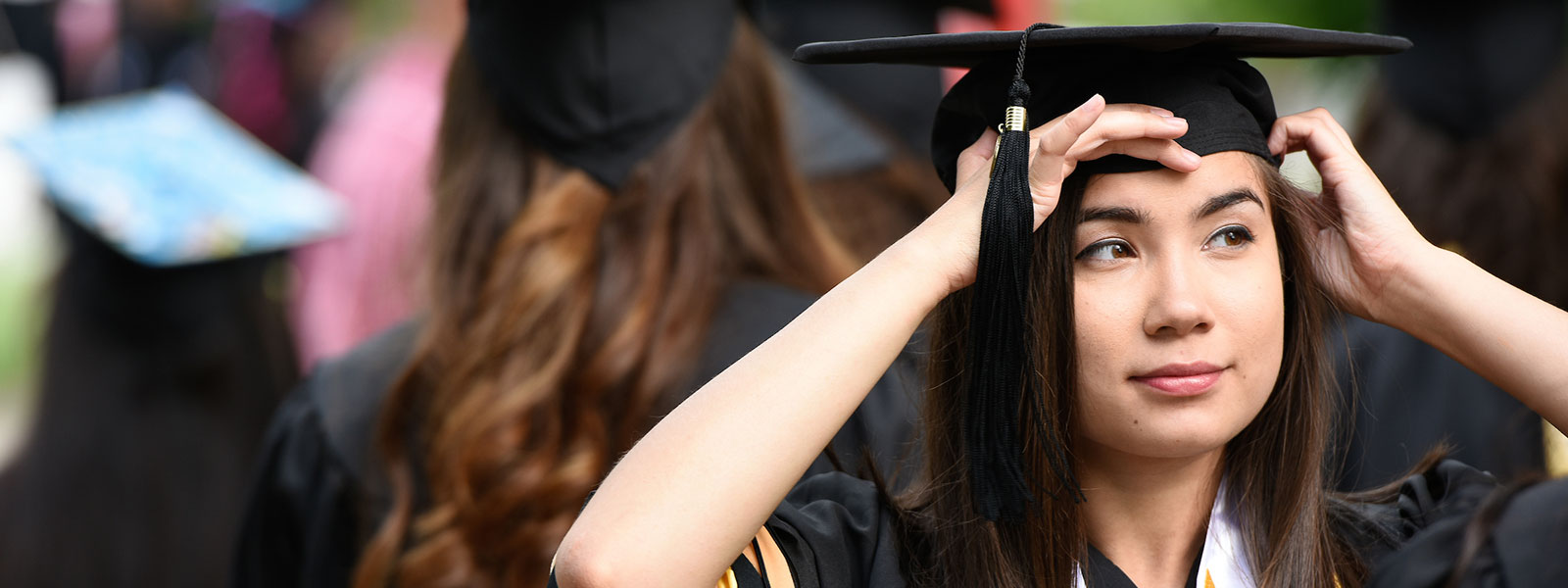 Student putting on her graduation cap